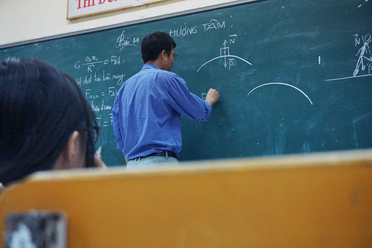 Professor writing on a chalkboard